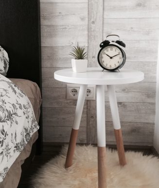 A white table with an alarm clock on top of it.