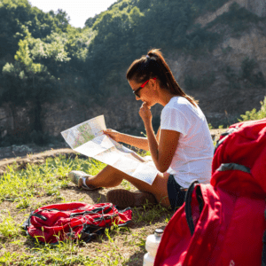 A woman sitting on the ground looking at a map.